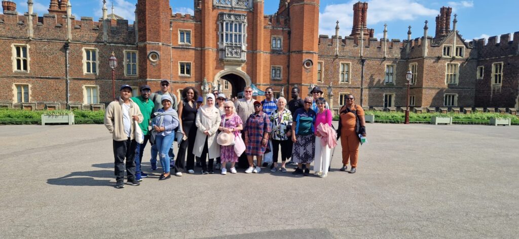 A group of people pose for a photo a Hampton Court Palace