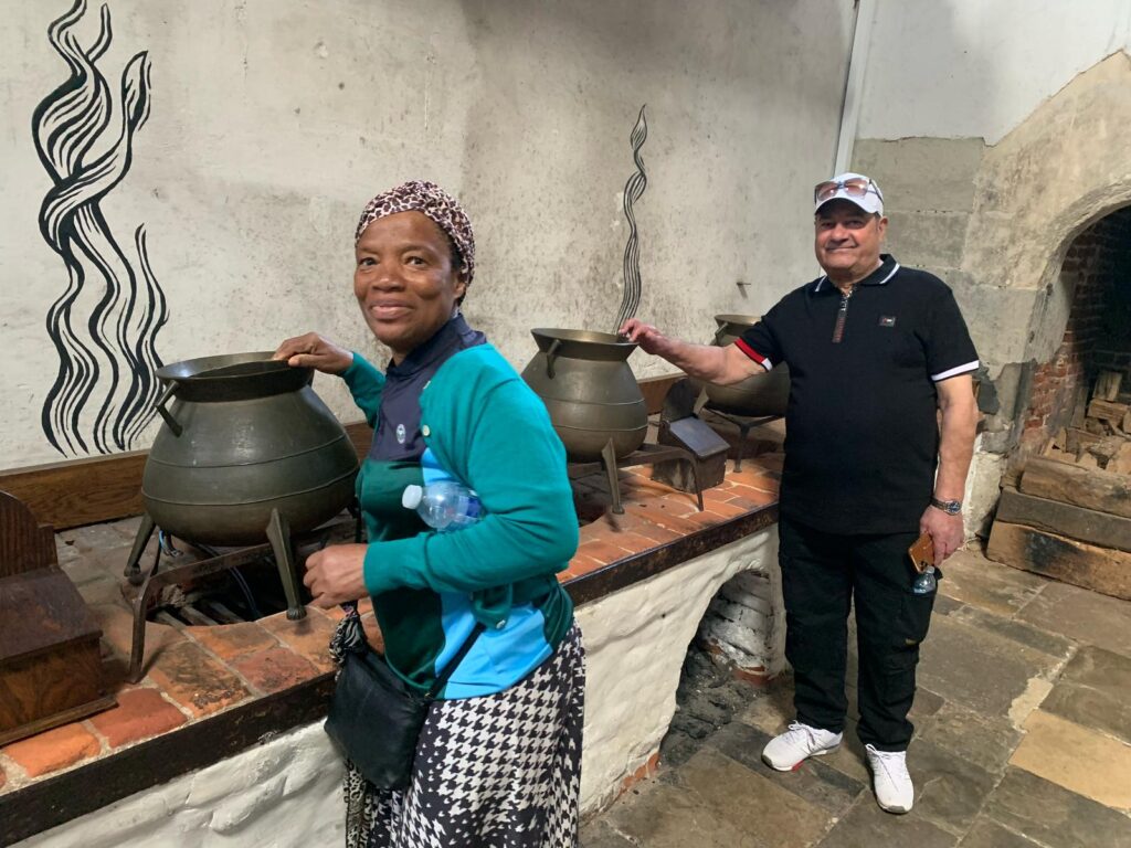 Two people stir pots in Hanpton Court Palace kitchens