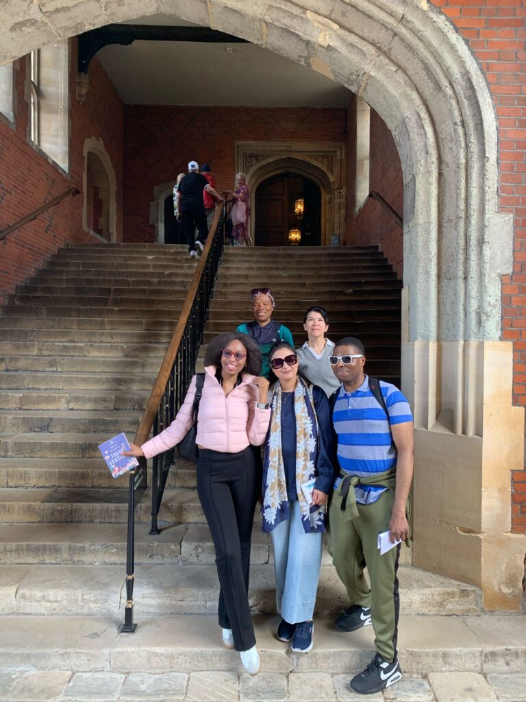 A group of people pose for a photo a Hampton Court Palace