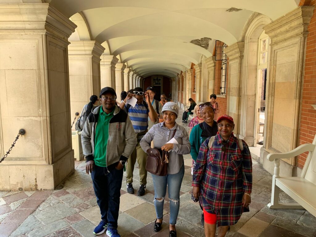 A group of people pose for a photo a Hampton Court Palace