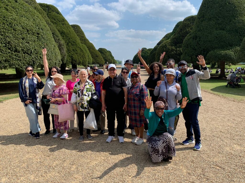 A group of people pose for a photo a Hampton Court Palace