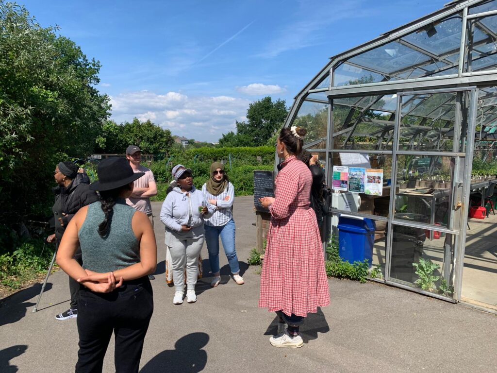 People standing around a greenhouse in Brockwell Park