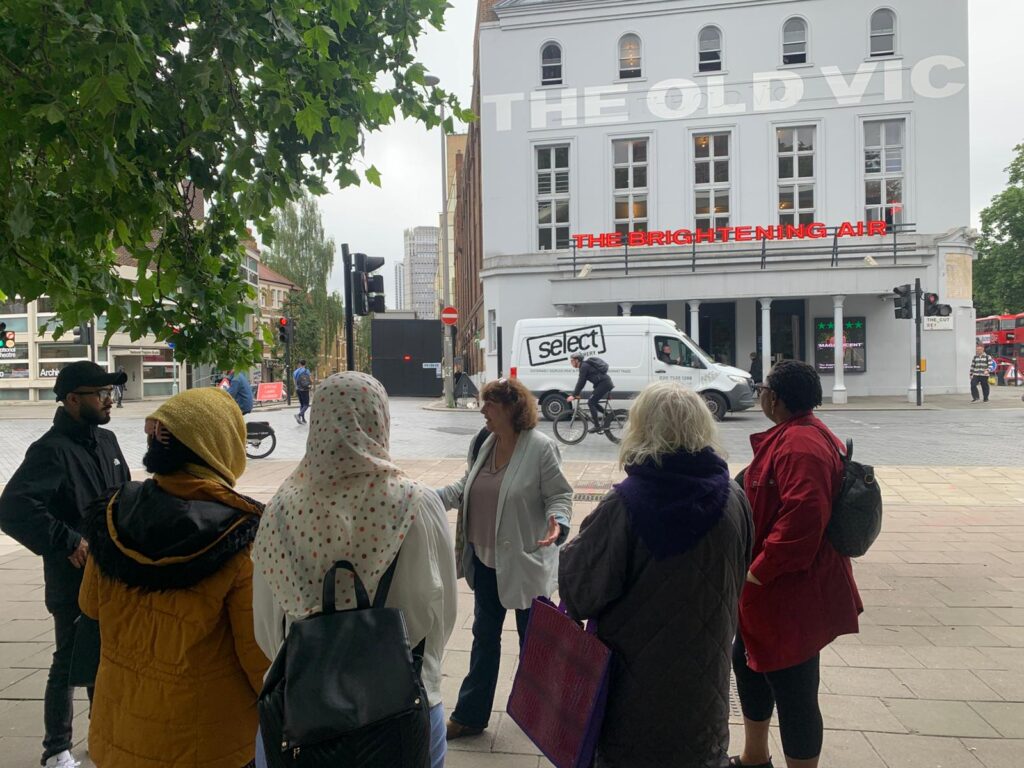 A group of people stand outside the Old Vic in London