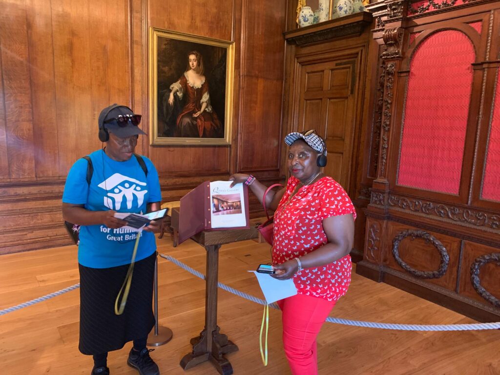 Two women wear headsets at Kensington Palace