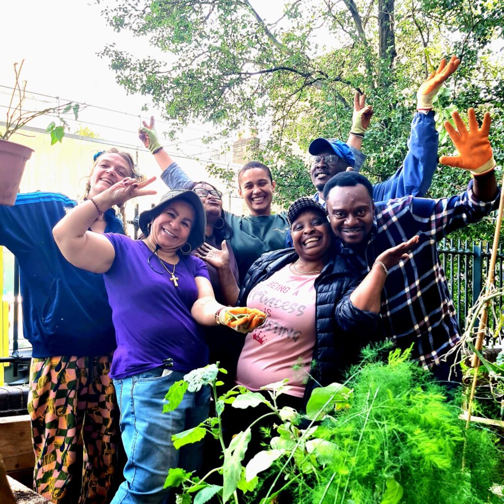A smiley group of gardeners pose for a photo outside the WCC garden